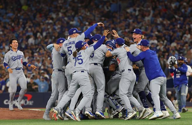 김혜성(왼쪽)이 월드시리즈 7차전 우승 순간 동료들을 향해 달려가고 있다. AFP=연합뉴스