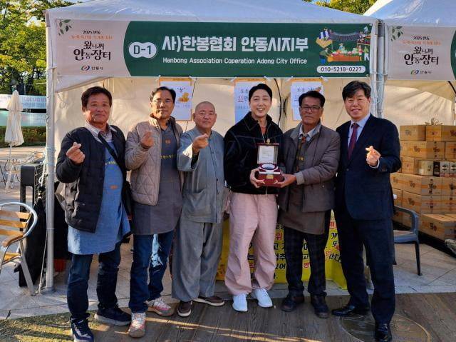 서울시청 앞 광장서 열린 '2025왔니껴안동장터'의 한 부스에서 안동 생산자와 김의승 전 서울시 행정부시장이 기념촬영을 하고 있다.