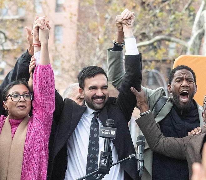 조란 맘다니 미국 민주당 뉴욕시장 후보(가운데)가 1일(현지시간) 뉴욕시 퀸즈자치구에서 열린 선거 행사에서 뉴욕시 선출직 공무원들과 함께 손을 들어보이고 있다. AFP연합뉴스