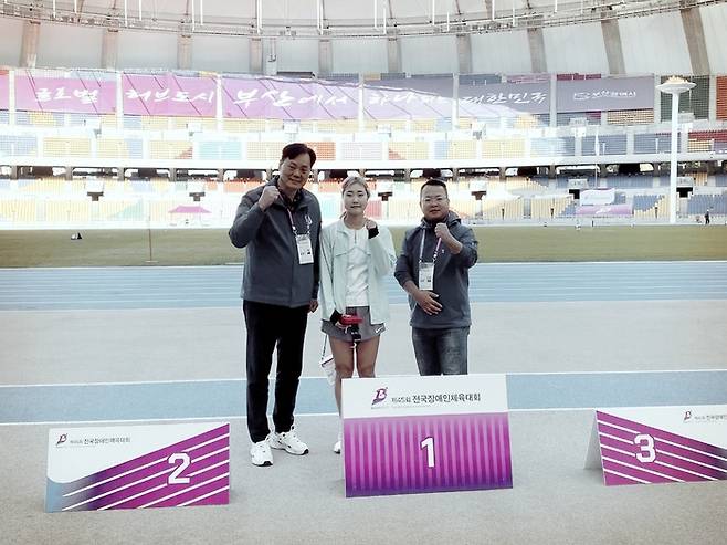 포항시청 신현진(가운데) 선수가 지난 2일 제45회 전국장애인체육대회 여자 시각장애 부문 400m에 이어 100m에서도 한국 신기록을 수립한 후 시상대에 올라 포즈를 취하고 있다.<경북장애인체육회 제공>