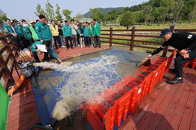 지난달 26일 광주 남구 빛고을농촌테마공원에서 열린 풍수해 대응 합동훈련에서 양수기 가동, 이동식 차수판 및 흡착마대 설치 등 재난관리자원 가동 훈련이 펼쳐지고 있다.(사진=저작권자(c) 연합뉴스, 무단 전재-재배포 금지)