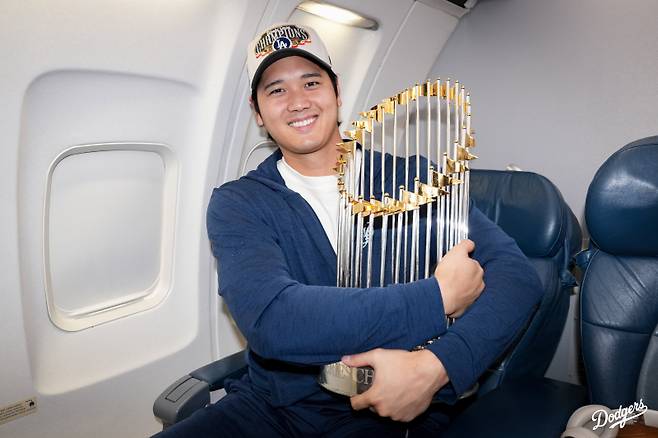 오타니가 전세기에서 우승 트로피를 들고 환하게 웃고 있다. 사진=다저스 SNS