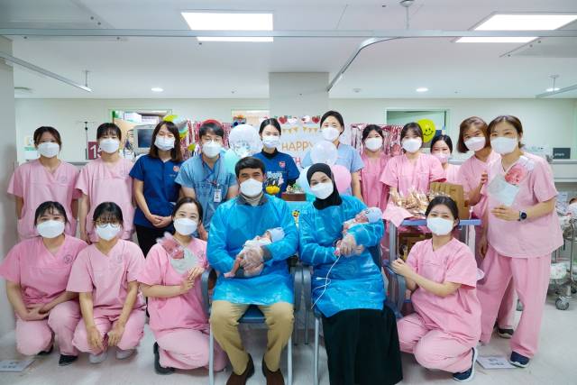 우즈베키스탄 출신인 하산보이·울리(앞줄 가운데) 씨 부부가 쌍둥이 형제를 안은 채 고대구로병원 신생아 중환자실 의료진과 100일 기념 사진을 찍었다. 사진 제공=고대구로병원