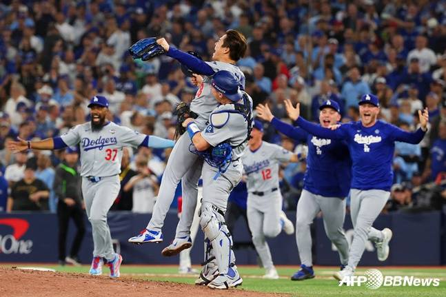 야마모토(가운데)가 월드시리즈 우승을 확정짓는 아웃카운트를 잡아내자 포수 스미스가 그를 들어올리며 기뻐하고 있다. /AFPBBNews=뉴스1