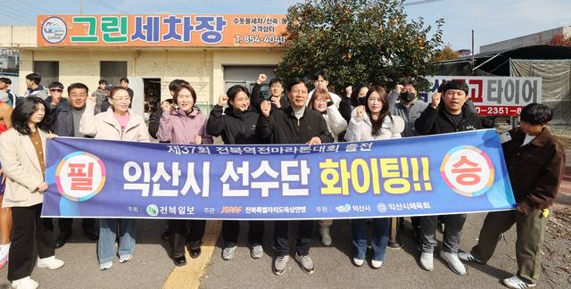 제4소구 출발지인 ‘익산 그린세차장 사거리’에서 조장희 익산시체육회 회장을 비롯한 22명의 체육회 직원들이 선수들을 격려하고 있다. 조현욱 기자.