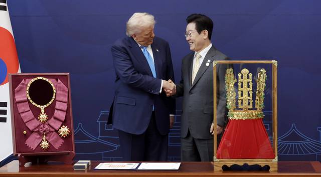 이재명 대통령이 지난 10월 29일 경북 경주박물관에서 도널드 트럼프 미국 대통령에게 ‘천마총 금관 모형’을 선물한 뒤 악수하고 있다. 왼쪽은 이 대통령이 트럼프 대통령에게 수여한 무궁화대훈장.<대통령실통신사진기자단·연합뉴스>