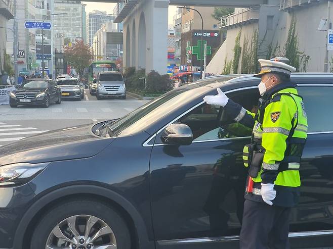 4일 오전 연세대학교 정문 앞 삼거리에서 경찰관이 꼬리물기 차량을 계도하고 있다. 사진=최승한 기자