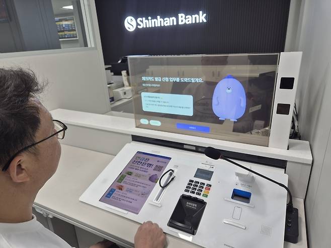 3일 서울 용산구 신한은행 숙명여자대학교지점에 방문한 고객이 ‘AI 몰리창구’에서 업무를 진행하는 모습. [사진 출처 = 신한은행]