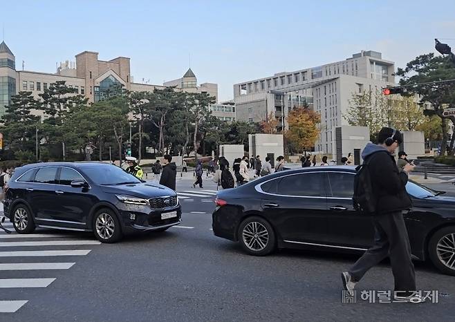 4일 오전 서울 서대문구 연세대 교차로에서 보행자들이 꼬리물기 차량을 피해 길을 건너고 있다. 이용경 기자
