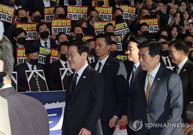 시위하는 국민의힘 의원들 앞 지나는 이 대통령 (서울=연합뉴스) 이재명 대통령이 4일 내년도 정부 예산안에 대한 시정연설을 하기 위해 서울 여의도 국회에 도착해 피켓시위를 하는 국민의힘 의원들 앞을 지나고 있다. 국민의힘 의원들은 추경호 전 원내대표에 대한 내란특검팀의 영장청구에 반발하며 야당 탄압 중단을 촉구했다. 2025.11.4 [국회사진기자단] photo@yna.co.kr