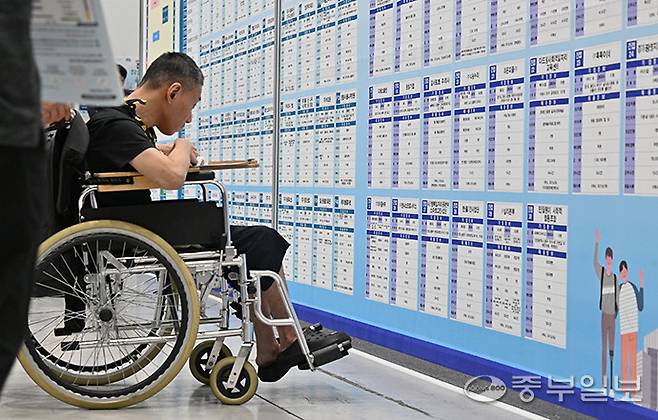 지난해 9월 4일 오후 수원시 수원메쎄에서 열린 '2024 장애인 취업박람회'에서 한 구직자가 휠체어를 타고 구직정보를 살펴보고 있다. 김경민기자