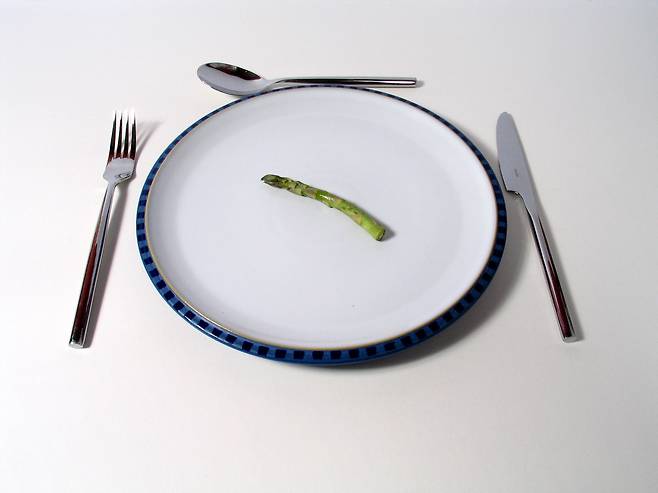 아스파라거스 한조각이 놓인 접시과 식기류