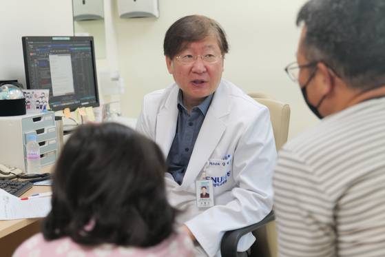 Kim Yoo-na, 8, left, visits Seoul National University Hospital with her father for a routine checkup and speaks with Prof. Kang Hyoung-jin of the Department of Pediatrics on Oct. 13. [SEOUL NATIONAL UNIVERSITY HOSPITAL]