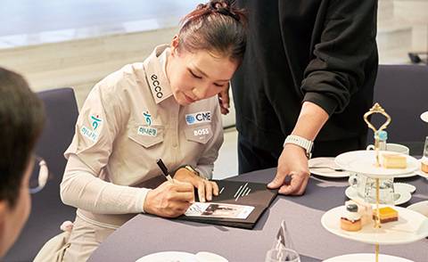 리디아 고가 포토앨범 위에 진심을 담아 사인을 하고 있다