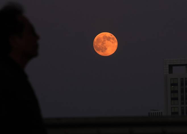 5일 오후 서울 서초구 잠수교를 걷는 시민 위로 슈퍼문이 떠오르고 있다. 뉴시스