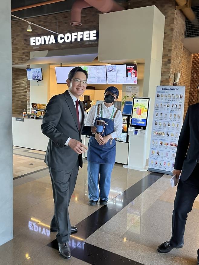 지난 1일 경북 경주 한화리조트 내 이디야커피 매장 앞에서 이재용(왼쪽) 삼성전자 회장이 제갈모씨에게 커피를 받고 이동하고 있다. 본인 제공