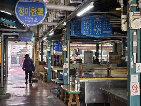 구암현대시장(창원시 마산회원구 구암동) 무허가 상가들이 영업을 중단했다. 한 시민이 6일 오전 운영을 멈춘 상가 주위를 지나고 있다. /최석환 기자