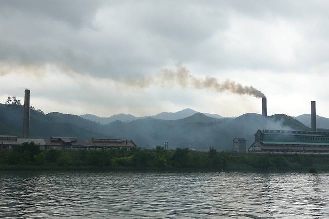 압록강 유람선에서 바라본 북한 땅. 평안북도 청수군 청수노동자지구의 한 공장에서 연기가 피어오르고 있다. <박진관기자>