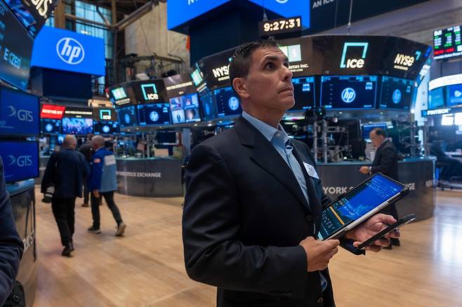 5일(현지 시간) 뉴욕증권거래소(NYSE)에서 한 트레이더가 모니터를 바라보며 걸어가고 있다. [AFP]