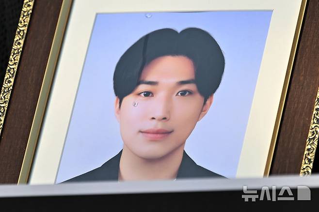 [광주=뉴시스] 이영주 기자 = 6일 오전 광주 북구 전남대학교 후문에서 열린 민주사회를위한변호사모임 광주지부의 전남대 교수 갑질 사건 진상규명 촉구 기자회견, 교수의 갑질로 숨진 대학원생 고(故) 이대원씨의 영정사진 위로 어머니가 흘린 눈물이 흐르고 있다. 2025.11.06. leeyj2578@newsis.com