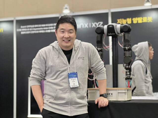 황성재 엑스와이지 대표가 로보월드 2025 부스에서 기념 사진을 찍고 있다. (사진=지디넷코리아 신영빈 기자)