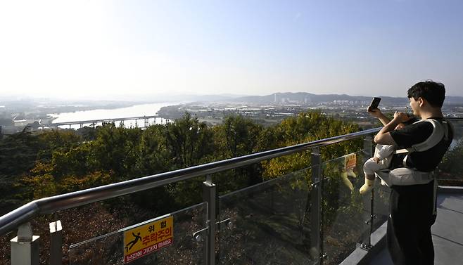 화원유원지 상화대 전망대에서 한 시민이 아이를 안고 낙동강을 배경으로 사진을 찍고 있다. 전망대에 오르면 낙동강 본류와 금호강이 한눈에 합쳐지고, 멀리 강정보와 대구 도심이 시원하게 펼쳐진다. 가족 단위 방문객들이 가장 많이 찾는 포토 명소이자 휴식 공간이다.이윤호 기자 yoonhohi@yeongnam.com