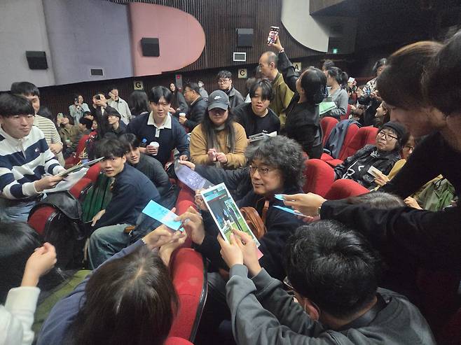 8일 광주광역시 동구 충장로의 광주극장을 찾아간 봉준호 감독이 둘러싼 팬들에게 일일이 사인해주고 있다./신정선 기자