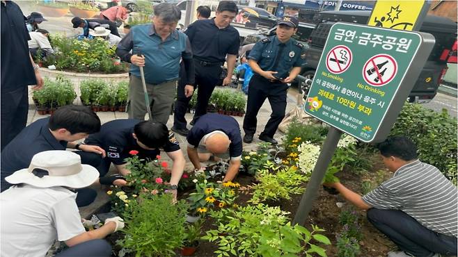 경찰관, 구청 직원들이 주취자들과 함께 서울 금천구 은행어린이공원의 화단을 정비하는 모습. /사진제공=서울 금천경찰서.