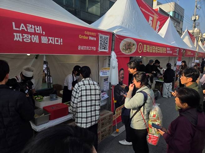 '꿀배LA갈비 짜장라면'을 먹기 위해 대기하고 있는 사람들. 이날 현장에서는 갓 생산된 농심 라면 패키지를 배낭같은 모양의 봉지에 담아 등에 매고 다니는 사람들의 모습도 눈에 띄었다. /사진=차현아 기자.
