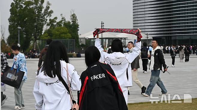 [청두(중국)=뉴시스] 윤정민 기자 = 9일 오후 중국 청두 동안호 스포츠파크 다목적체육관 앞에서 '2025 리그 오브 레전드(LoL) 월드 챔피언십'을 관람하려는 T1 팬이 기념 촬영을 하고 있다. 2025.11.09. alpaca@newsis.com