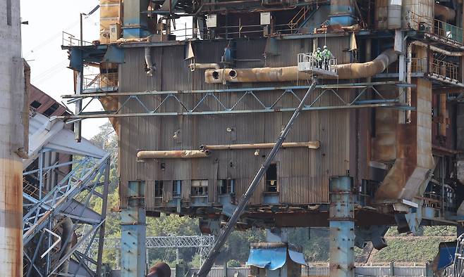 울산화력발전소 보일러 타워 붕괴 사고 나흘째인 9일 발전소 내부에서 보일러 타워 4·6호기 발파 사전 작업을 위해 고소작업차가 투입돼 타워 외부를 살피고 있다.&nbsp; 연합뉴스