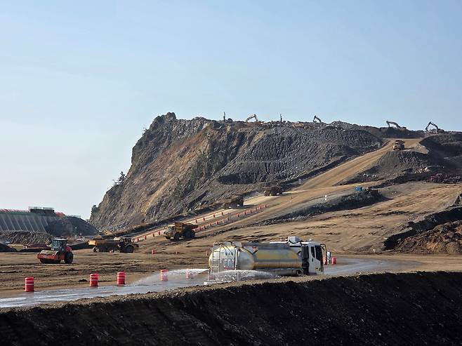 지난 6일 찾은 울릉공항 건설 현장 모습. 울릉도 남쪽 사동항 앞 가두봉을 깎아 활주로 부지로 메우는 공사가 한창이다. 덤프트럭이 흙을 실어 나르고 살수차가 흙먼지를 가라앉히고 있다. /김민정 기자