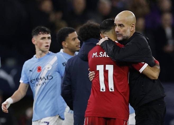 펩 과르디올라 맨체스터 시티 감독이 10일(한국시간) 영국 맨체스터 에티하드 스타디움에서 열린 2025~26 잉글랜드 프리미어리그(EPL) 11라운드 리버풀과의 홈 경기에서 3-0으로 승리한 뒤 모하메드 살라와 포옹하고 있다. 로이터 연합뉴스