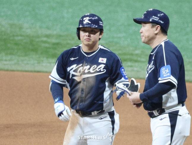문현빈(왼쪽)이 안타를 날리고 이동욱 코치에게 보호장구를 건네고 있다. /사진=김진경 대기자
