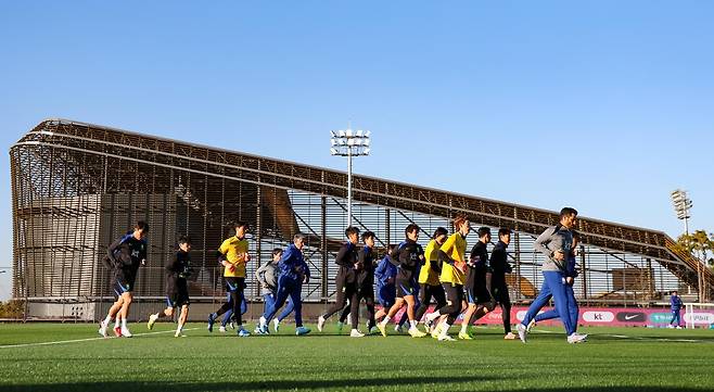한국 축구 국가대표팀 선수들이 10일 충남 천안시 대한민국 축구종합센터에서 러닝을 하고 있다. 이달 A매치 2연전을 앞둔 대표팀은 이날 천연잔디와 인조잔디가 혼합된 하이브리드 잔디 구장에서 훈련했다. 뒤편에 보이는 건물은 4000석 규모의 스타디움이다. 2022년 4월 착공한 대한민국 축구종합센터는 내달 준공을 앞두고 있다. 천안=뉴시스