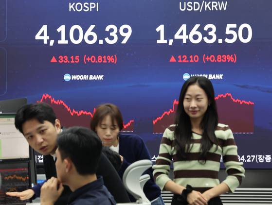 코스피가 4,106.39에 거래를 마친 11일 서울 중구 우리은행 본점 딜링룸에서 딜러들이 대화하고 있다. 연합뉴스.