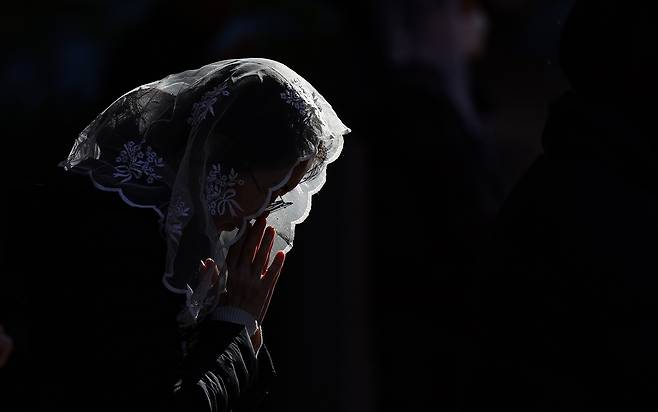 Two days ahead of Suneung, the College Scholastic Ability Test, a mother is praying for her children at a catholic church in Jung-gu, Daegu, at a test-taker supporting worship on Tuesday. (Yonhap)