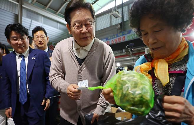 이재명 대통령이 지난 5월 대선후보 시절 경북 영천시 영천공설시장 한 가게에서 영천 지역화폐로 말린 고추를 구매하고 있다. ⓒ연합뉴스