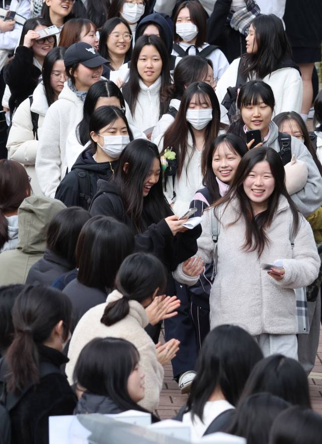 2026학년도 대학수학능력시험을 하루 앞둔 12일 오전 부산 사상구 주례여고에서 수험표를 배부받은 고3 수험생들이 후배들과 선생님의 응원을 받으며 밝은 표정으로 학교를 빠져나가고 있다. 올해 부산지역 수능 지원자는 2만 8883명이며 이들은 13일 부산지역 62개 시험장에서 수능 시험에 응시한다. 정종회 기자 jjh@