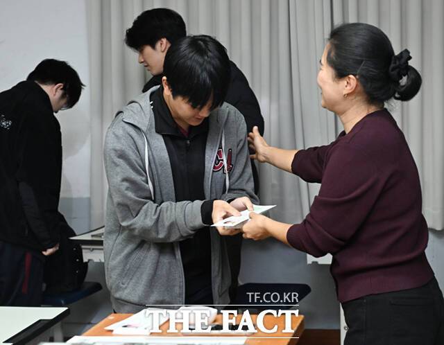 담임선생님으로부터 수험표와 응원 선물을 받는 고3 수험생.