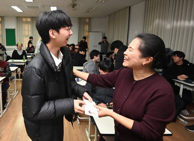“시험 잘봐”  : 2026학년도 대학수학능력시험을 하루 앞두고 예비소집이 이뤄진 12일 오전 서울 종로구 중앙고에서 한 담임선생님이 고3 수험생에게 수험표를 건네며 격려하고 있다.  박윤슬 기자
