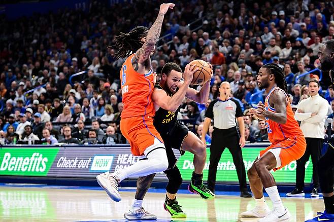 골든스테이트 스테판 커리(가운데)가 12일(한국시간) 페이콤 센터서 열린 오클라호마시티전 도중 상대 수비 2명 사이를 뚫고 있다. 커리는 복귀전에서 11점에 머물렀고, 골든스테이트는 완패를 당했다. 오클라호마시티(미 오클라호마주)|AP뉴시스