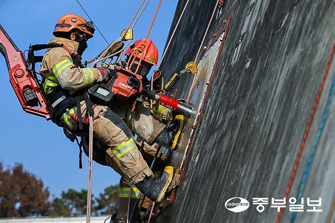 13일 오후 용인시 경기소방학교 붕괴사고훈련장에서 진행된 천공파괴 훈련에 참가한 소방관계자가 레펠에 매달린 상태로 벽에 천공을 내고 있다. 임채운기자