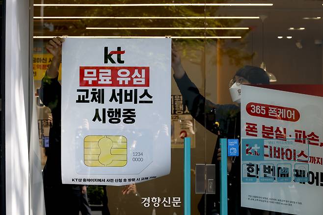 KT가 해킹 피해 후속 대책으로 전 가입자를 대상으로 무상 유심 교체를 시작한 지난 5일 서울 KT플라자 여의도역점에서 직원들이 유심 교체 안내 포스터를 붙이고 있다. 문재원 기자