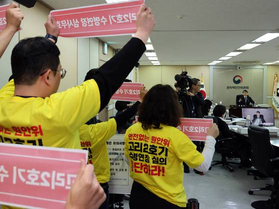 Members of civic and environmental groups call for an end to the lifetime extension of Kori-2 Nuclear Power Plant during a plenary meeting of the Nuclear Safety and Security Commission (NSSC) in Jung District, central Seoul, on Nov. 13. The NSSC approved the extension during the meeting. [NEWS1]