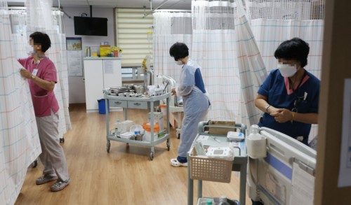 서울의 한 요양병원에서 간호사와 간병인들이 환자들을 살펴보고 있다. [이승환 기자]