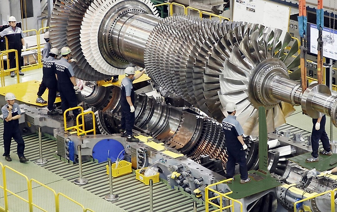 발전기용 가스터빈의 최종조립을 위해 로터 블레이드를 설치하는 모습 [사진=두산에너빌리티]