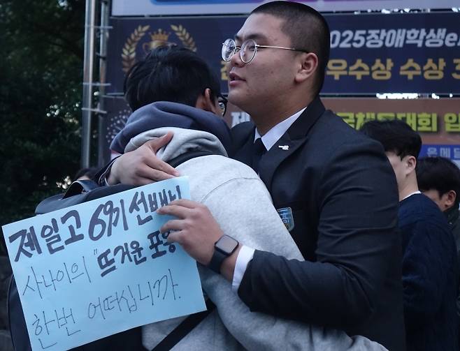 수험생 선배 안아주는 후배 - 2026학년도 대학수학능력시험일인 13일 오전 제주도교육청 95지구 제1시험장인 남녕고등학교 앞에서 오승훈 제주제일고등학교 학생회장이 수험생 선배들을 안아주는 프리허그 응원을 하고 있다.  뉴시스