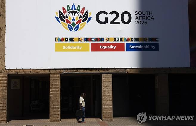 남아공 요하네스버그 시내 G20 광고판 13일(현지시간) 남아프리카공화국 요하네스버그 시내의 G20 정상회의를 알리는 간판 아래 한 보행자가 지나가고 있다. 2025.11.13 [EPA=연합뉴스]