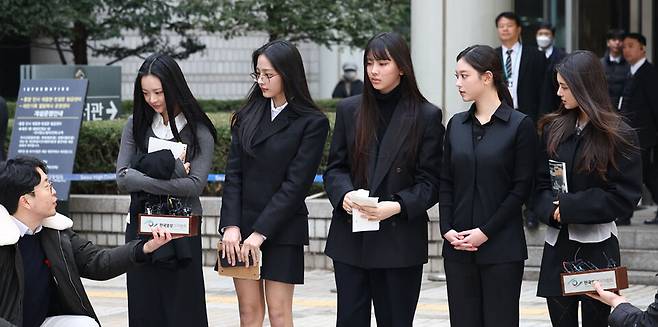 걸그룹 뉴진스(NJZ)가 7일 서울 서초구 서울중앙지방법원에서 열린 '기획사 지위보전 및 광고계약 체결 등 금지' 가처분 신청의 심문기일을 마친 뒤 법원 청사를 나서며 취재진 질문에 답하고 있다.왼쪽부터 하니, 민지, 혜인, 해린, 다니엘. ⓒ연합뉴스